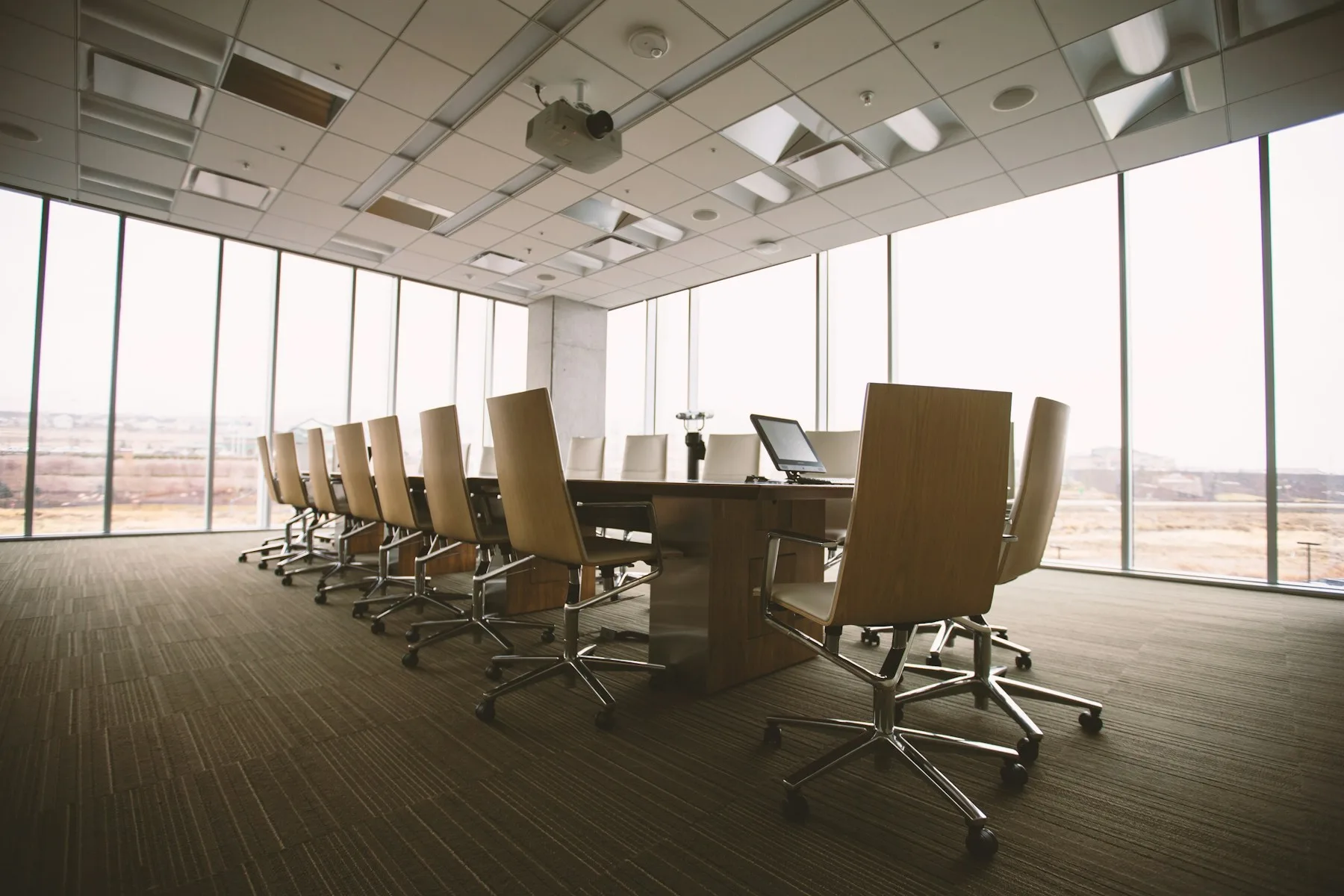 An empty boardroom table and chairs