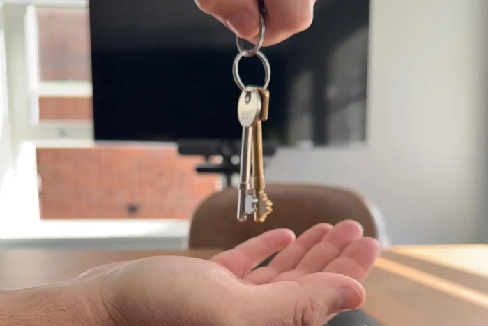 A set of keys handed over a desk